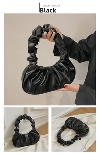 Detail van de zwarte geplooide cloud bag met scrunchie handvat en modern halfmaan model
