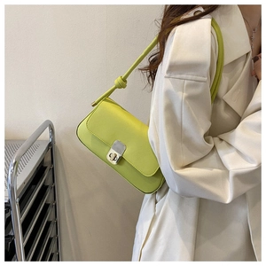 Detail of neon green shoulder bag featuring silver twist lock and knotted strap design