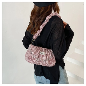 Détail du sac nuage plissé rose avec chaîne florale argentée et texture en tissu doux
