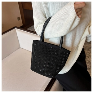 Detail of black rhinestone bucket bag showing sparkling texture and leather handles