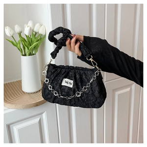 Détail du sac nuage plissé noir avec texture bulles et chaîne métallique à fleurs