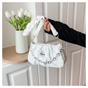 Détail du sac nuage plissé blanc avec chaîne à fleurs métalliques et texture de tissu