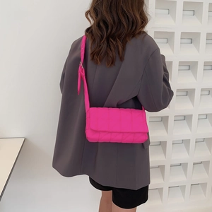 Quilted crossbody bag in vibrant pink nylon with wide shoulder strap on model