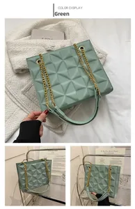 Détail du sac bandoulière vert avec motif géométrique en relief et chaîne dorée