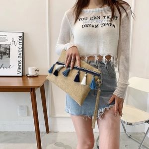 Handmade woven straw envelope clutch bag with blue tassels and a wristlet strap