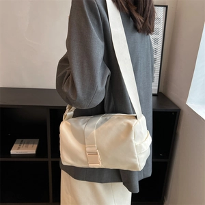 Minimalist white waterproof crossbody bag with adjustable wide strap and buckle detail