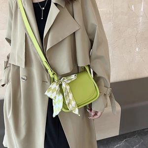 Borsa a tracolla in pelle verde lime con sciarpa di seta su modella in cappotto