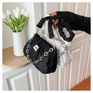 Détail de la chaîne florale en métal et texture plissée sur ces sacs à bandoulière