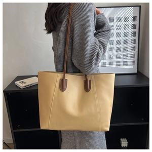 Detail of cream tote bag with contrast brown shoulder straps and fine stitching