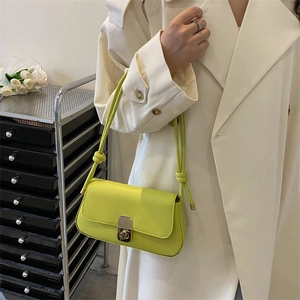 Neon green rectangular shoulder bag with silver turn-lock and knotted rope strap detail