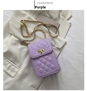 Detail of purple quilted crossbody bag with gold chain strap on white blazer