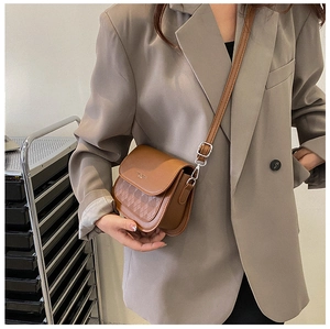 Side view of caramel PU leather crossbody bag with quilted flap and adjustable strap