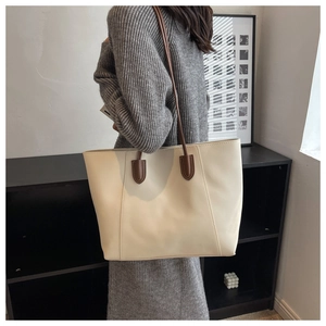Detail view of large minimalist tote bag in cream white and brown leather strap