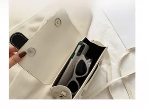 Vue intérieure du mini sac besace montrant le rangement du mobile et des lunettes