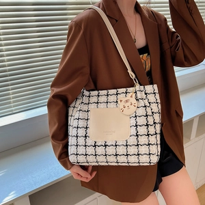Classic black and white checkered tote bag with leather pocket and cartoon tiger charm