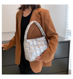 Detail of silver metallic quilted puffer handbag with wide shoulder strap