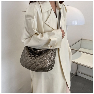 Detail of metallic bronze quilted crescent bag featuring stylish diamond lattice texture