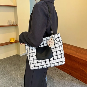 Fashionable black and white checkered tweed tote bag with front pocket and tiger charm