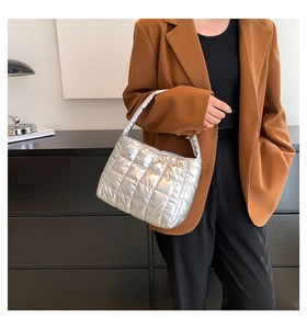 Detail of silver metallic quilted handbag with diamond stitching on chic blazer model