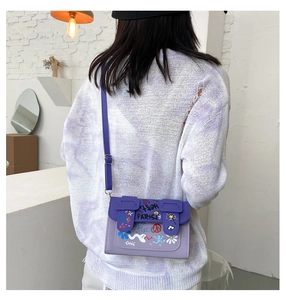 Détail du mini sac bandoulière violet avec graffitis artistiques et motifs dessinés à la main