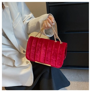 Détails du sac à bandoulière en velours rouge avec matelassage et chaîne dorée