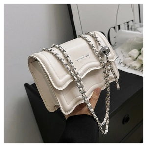 Detail of off-white PU leather crossbody bag with silver chain and metal ball ornament
