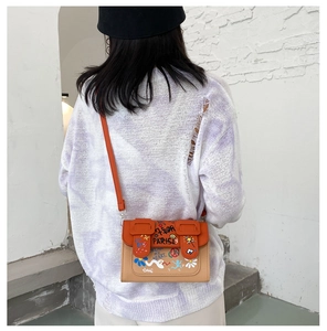 Détail d'un sac bandoulière graffiti avec rabat orange et motifs colorés mode