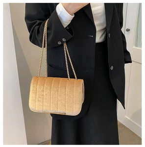 Vue détaillée du sac bandoulière en velours abricot matelassé avec chaînes dorées