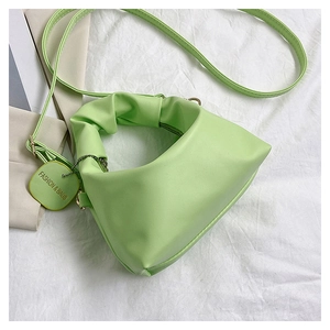 Detail view of the light green crossbody bag featuring a pleated cloud handle and strap