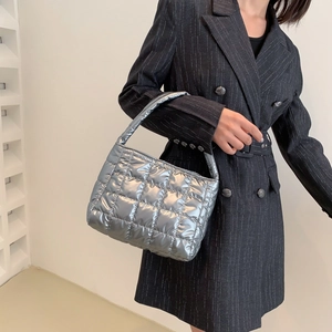 Quilted silver padded tote bag with metallic finish shown on a professional model