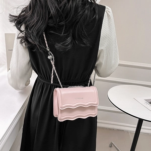 Pink wave pattern crossbody bag with chain strap shown on a model for daily style