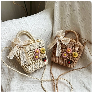 Detail of woven straw bags with colorful crochet flowers and lace ribbon bow ties