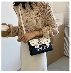 Détail d'un mini sac bandoulière avec graffitis colorés et contraste noir et blanc