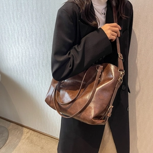 Retro brown leather tote bag for women featuring long straps and vintage golden hardware