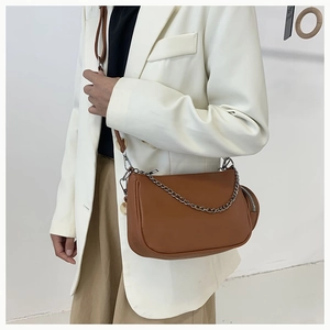 Close-up of brown crescent crossbody bag with silver chain and detachable coin purse