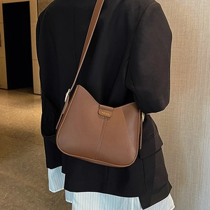 Brown vintage hobo crossbody bag with adjustable strap and fashion lettering on model