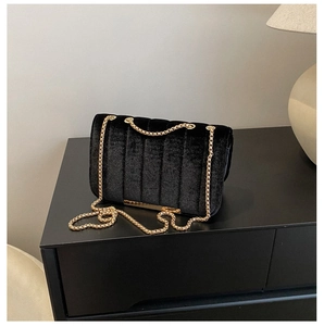 Vue détaillée du sac bandoulière en velours noir avec surpiqûres et chaîne dorée