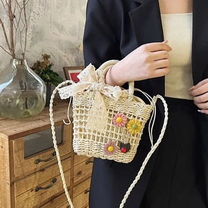 Handcrafted cream woven straw bag with lace bow, floral accents and shoulder strap