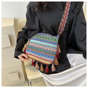 Bohemian woven crossbody bag with colorful geometric patterns and long side fringes
