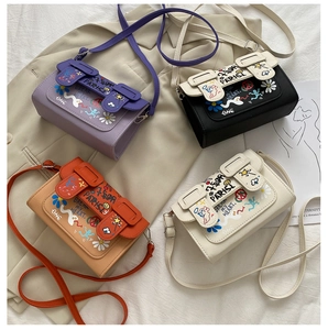Vue à plat de petits sacs bandoulière en violet, noir, orange et tons beiges