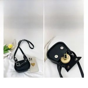 Détail du sac selle en similicuir noir montrant l'espace pour téléphone et cosmétiques