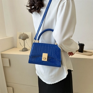 Bright blue crocodile embossed leather handbag with woven handle and gold clasp