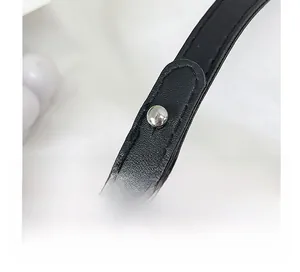 Détail de la bandoulière en cuir grainé noir avec boucle de réglage en métal argenté
