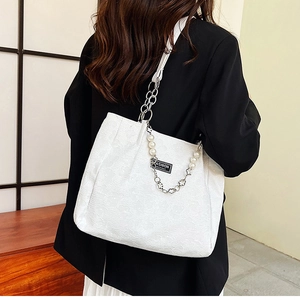 Détail du sac blanc à motif floral avec chaîne en métal et perles décoratives