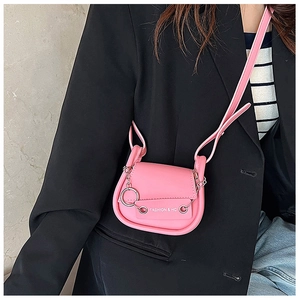 Détail du sac besace rose avec chaîne argentée et texture en cuir PU lisse