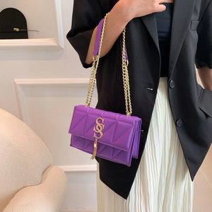 Chic purple quilted crossbody bag with golden chain strap and tassel detail on model