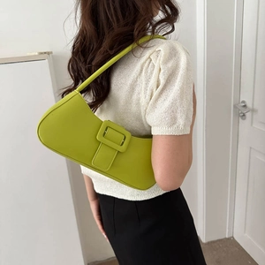 Minimalist lime green semi-moon shoulder bag in matte leather worn by a model