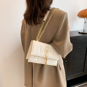 White quilted crossbody bag with gold chain strap and tassel detail for women