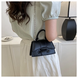 Detail shot of a black matte crossbody bag with silver chain strap and top handle