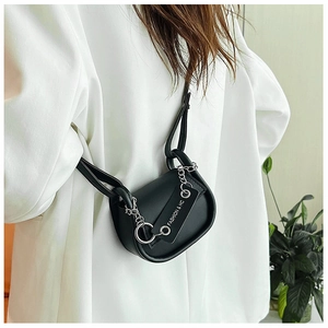 Détail d'un sac besace en cuir noir avec chaîne métallique et étiquette Fashion & HC